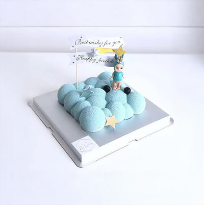 A cake adorned with a blue cloud and a small boy figurine, adding a charming touch to the dessert.