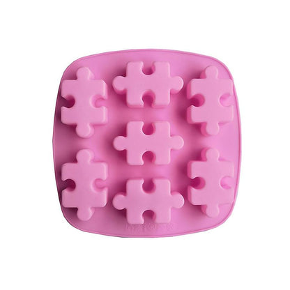 Pink silicone mold with eight puzzle piece shapes. The mold is square with rounded edges, designed for making themed treats or ice cubes.