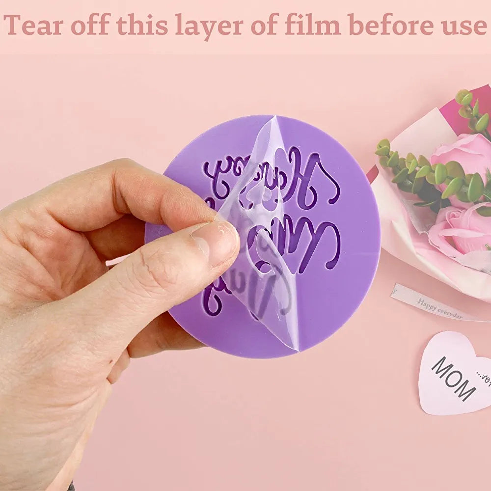 Image description for accessibility: A close-up view of a hand holding a round purple fondant embosser cookie stamp, which features the text &quot;Happy Mother&