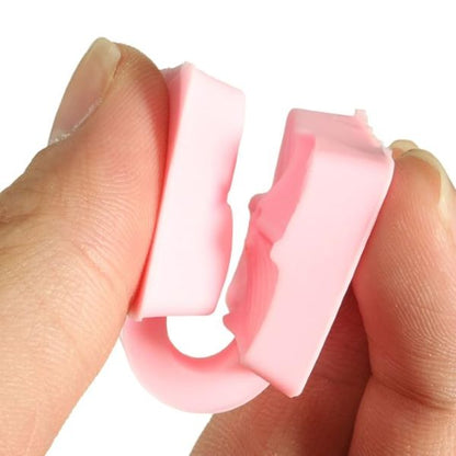 A person?s hand is holding a small, pink silicone mould designed in the shape of flower petals. The mould consists of two sections that can be pressed together. The surface of the mould features intricate details resembling flower petal patterns. The overall appearance is flexible and smooth, showcasing the silicone material.