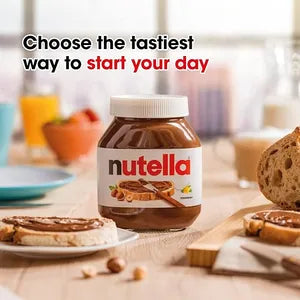 The image features a jar of Nutella hazelnut spread with cocoa prominently displayed in the center. Surrounding the jar are slices of bread topped with the spread, suggesting ways to enjoy it. In the background, there are colorful bowls and glasses, indicating a breakfast setting. The text &quot;Choose the tastiest way to start your day&quot; is displayed above the jar in bold, inviting font.