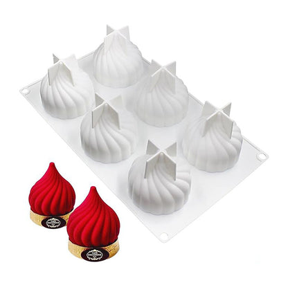 A silicone mould featuring eight spiral dome shapes with decorative tops, presented on a clear plastic base. Next to the mould, there are two finished red desserts resembling the moulds, placed on round, branded bases.