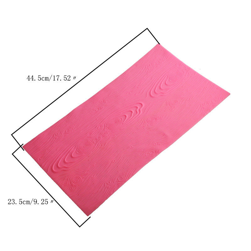 A pink silicone mat designed for fondant impressions, featuring a textured woodgrain pattern. The mat measures approximately 44.5 cm (17.52 inches) in length and 23.5 cm (9.25 inches) in width.