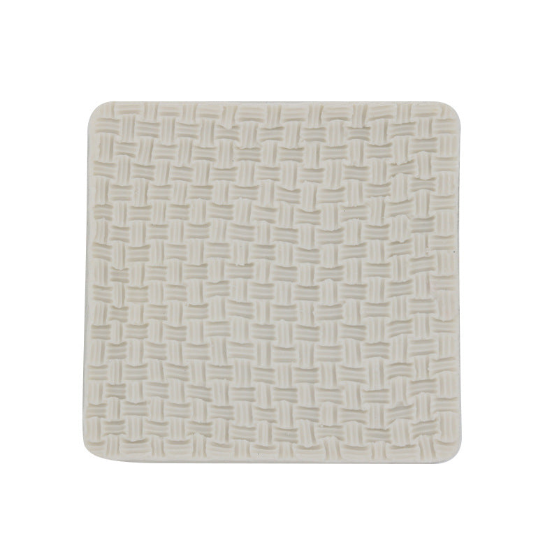 A square silicone mould with a textured surface that resembles a knitted pattern. The mould is light cream in color, featuring a woven design with raised elements that create a three-dimensional effect.