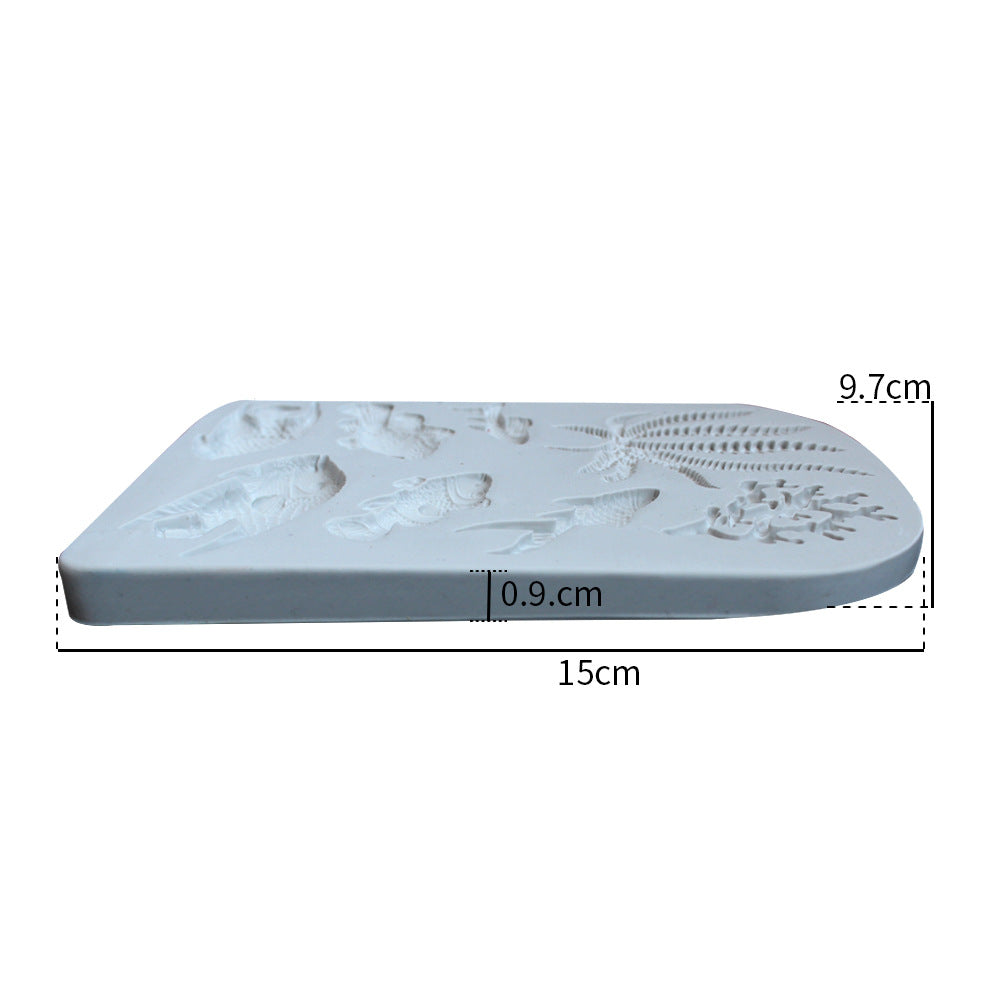 A white silicone mold with various sea fish and marine life designs is displayed. The mold measures 15 cm in length, 9.7 cm in width, and 0.9 cm in thickness. The top surface features detailed impressions of fish and aquatic plants, showcasing intricate designs suitable for crafting or baking. The edges of the mold are slightly rounded.