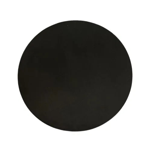 A circular cake board with a smooth black surface.