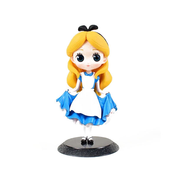 A whimsical figurine of a young girl resembling a classic storybook character. She has long, wavy blonde hair and is wearing a blue dress with a white apron. The figurine stands on a round black base, with her hands slightly raised, showcasing her playful pose. She has large, expressive eyes and a black headband in her hair.