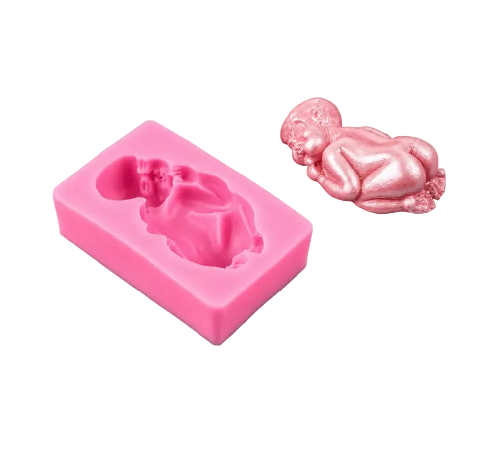 Pink silicone mold shaped like a baby with a pink baby figurine on a black background
