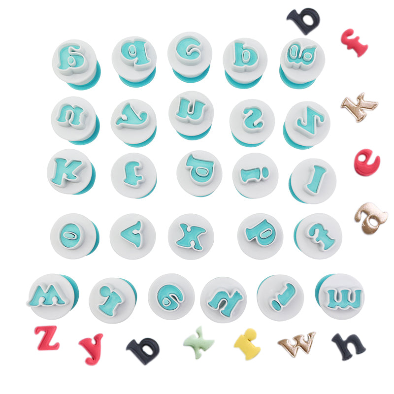 A set of 26 plunger cutters for lowercase alphabet letters arranged in a grid. Each cutter has a round base with a light blue top featuring the letter design. Several letters are shown in various colors placed around the cutters, including red, black, and gold.