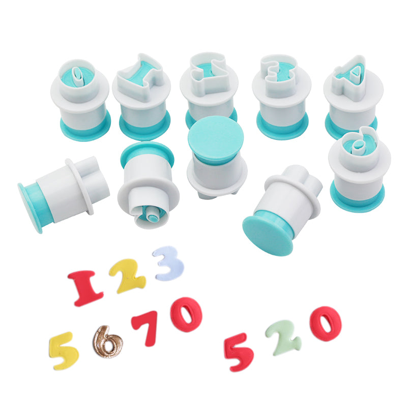 A set of ten plunger cutters in various shapes resembling numbers. The cutters feature a combination of white and turquoise colors, with the cutting ends designed to form numbers. Surrounding the cutters, there are colorful number-shaped candies or dough cutouts in red, yellow, and light blue. The numbers include 0, 1, 2, 3, 5, 6, and 7, displayed prominently on a white background.