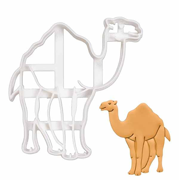 A white plastic camel-shaped cookie cutter is displayed next to a completed cookie shaped like a camel. The cookie is light brown with details that resemble a camel&