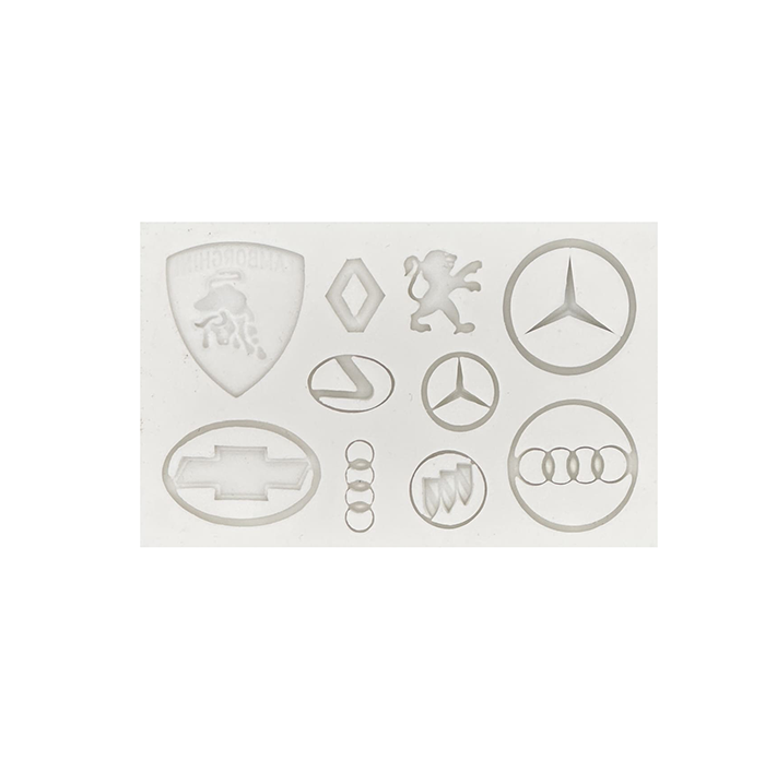 The image features a silicone mold designed for creating car logos. The mold includes various logos such as a Lamborghini shield, Renault logo, a lion emblem, Mercedes-Benz stars, Chevrolet bowtie, Audi rings, and others. The mold has a smooth, white appearance, showcasing distinct shapes of each logo imprinted in a flexible material, suitable for crafting.