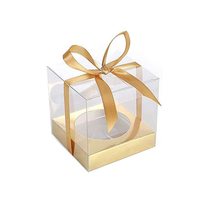 A clear PVC cupcake box with a gold base and a decorative gold ribbon tied in a bow on top. The box is designed to hold a single cupcake, showcasing its transparent sides.