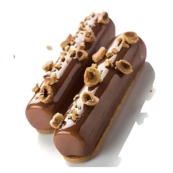 Two cylindrical chocolate desserts are displayed side by side. Each dessert features a glossy chocolate glaze, topped with crushed nuts and a decorative white drizzle. They rest on a light base, emphasizing their smooth, shiny appearance.