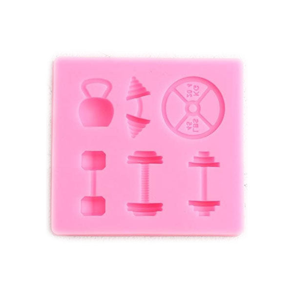 A pink silicone mold featuring various fitness-shaped cavities. The mold includes shapes of a kettlebell, a dumbbell, a barbell with weights, and a circular weight plate, all designed for making treats or candies in the shape of gym equipment.
