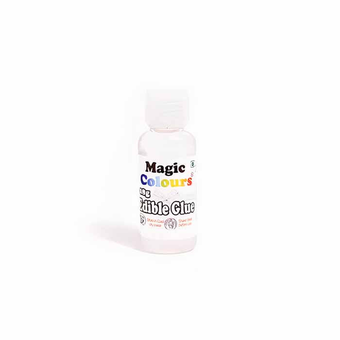 A clear plastic bottle of &quot;Magic Colours&quot; edible glue. The bottle has a white cap and features colorful text on the label, including the product name and the words &quot;edible glue.&quot; The contents of the bottle are transparent.