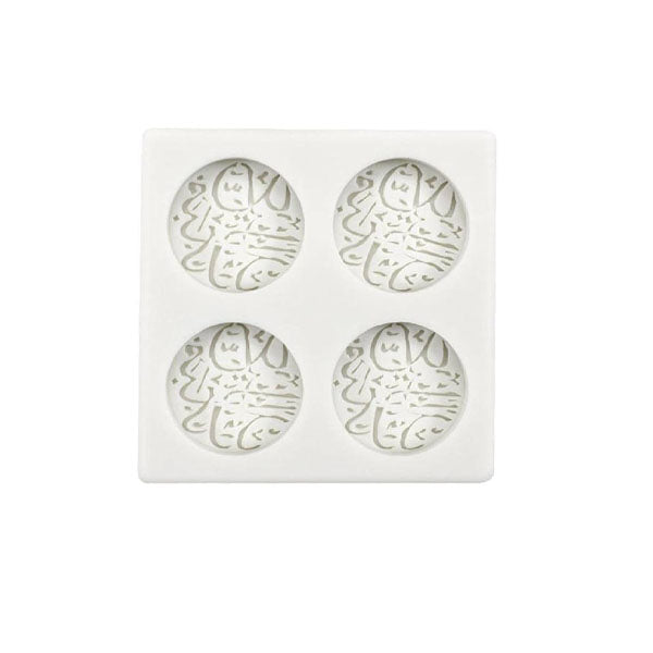 The image features a white silicone mold designed for creating items with Arabic text. The mold is square and contains four circular cavities, each embossed with intricate Arabic script. The overall design allows for the production of decorative items, suitable for celebrating Eid Mubarak.