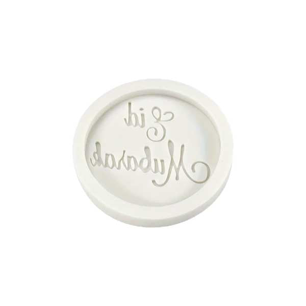 A white silicone mould in a circular shape, featuring the words "Eid Mubarak" in a decorative script inside the mould. The design has a raised lettering style, suitable for creating cake decorations or similar crafts.