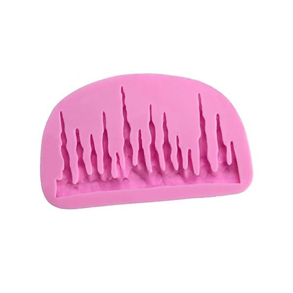 A pink silicone mold designed to create icicle shapes. The mold features various long, tapered designs that resemble icicles, all positioned closely together on a curved base.