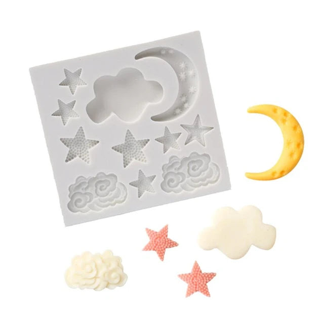 An image of a silicone mould designed for creating shapes of stars, moons, and clouds. The mould is square and features various designs, including five star shapes, three cloud shapes, and a crescent moon. Surrounding the mould are several finished pieces: a yellow crescent moon, a white cloud, a pink star, and two white cloud shapes. The stars are textured, and the clouds vary in design, showcasing a whimsical theme suitable for baking or crafting.