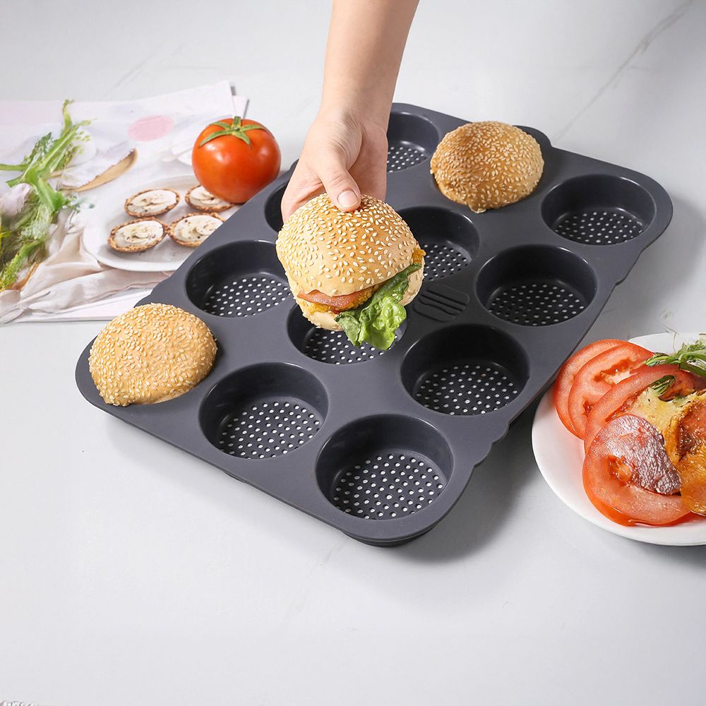A person holds a sandwich placed in a muffin pan, showcasing a creative food presentation.