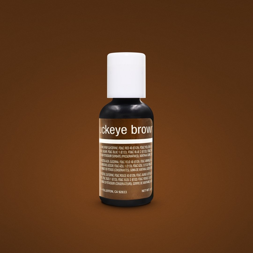 The image features a small bottle of liquid color gel labeled &quot;Buckeye Brown.&quot; The bottle has a white cap and a primarily black design with a brown label. The label contains product information, including ingredient details, and is set against a solid brown background. The bottle&