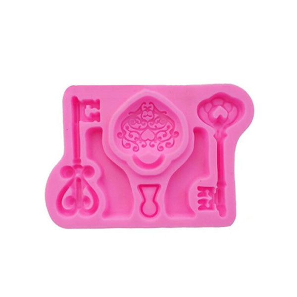 A pink silicone mould featuring various key shapes and a decorative design. The mould includes two different key designs, a heart-shaped key, and an ornate central shape. Each design is outlined and ready to be filled, suitable for creating cake decorations or crafts.
