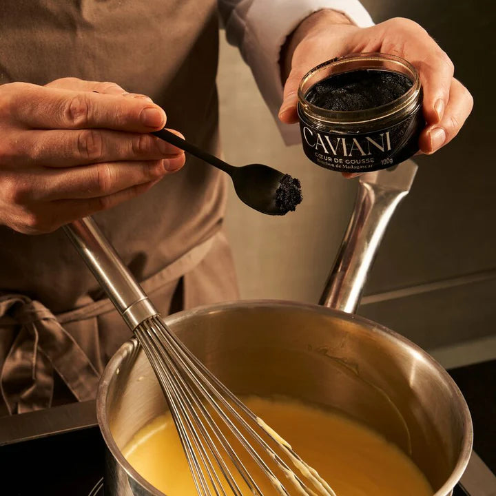 Person adding cavini to a dish with a whisk