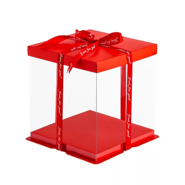 A square cake box made of clear PVC, featuring a red lid and a red base. The box is adorned with two red ribbons that have the phrase &quot;Just for you&quot; printed on them. The box has a height of 9.8 inches and a square base measuring 10 inches by 10 inches, designed for tall cakes or desserts.