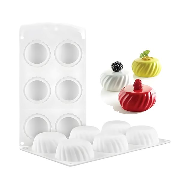 A round eclipse silicone mould with 8 cavities, displayed next to three colorful desserts. The mould is white with a smooth design, and the desserts include a red dome topped with a raspberry, a yellow dessert with a mint leaf and a blackberry, and a plain white dome. The mould is shown filled with white desserts ready for use.