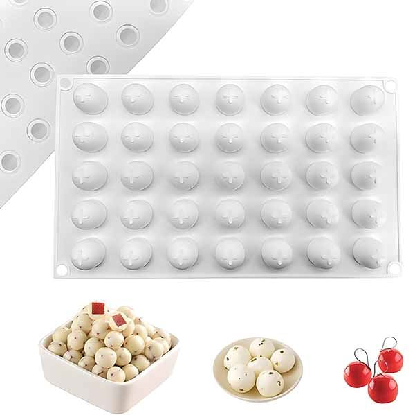 The image features a round ball silicone mold with 35 cavities, designed for creating small round shapes. The mold is predominantly white and has a smooth surface with evenly spaced spherical cavities. Below the mold, there are three bowls containing small round items: one bowl is filled with various white balls, another bowl has fewer white balls, and a third bowl contains red cherry-like balls. The image showcases the versatility of the mold for making different types of round confections or treats.