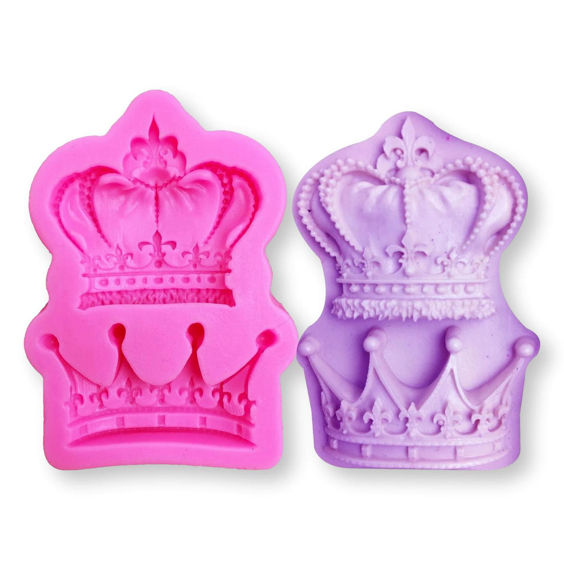 The image features two silicone molds shaped like ornate royal crowns. The mold on the left is bright pink, while the one on the right is light purple. Each mold has intricate detailing, including decorative elements like jewels and fluted edges. The molds are designed for creating crown-shaped confections or decorations. They are positioned against a plain white background.