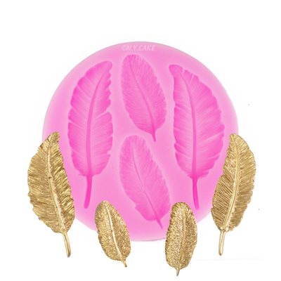 A pink silicone mould shaped like feathers, featuring five feather impressions. Surrounding the mould are four decorative golden feather pieces, showcasing intricate details.