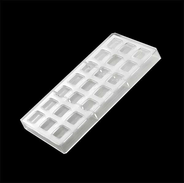 A clear plastic square chocolate mold with multiple rectangular cavities arranged in a grid pattern. The mold is shown on a black background.