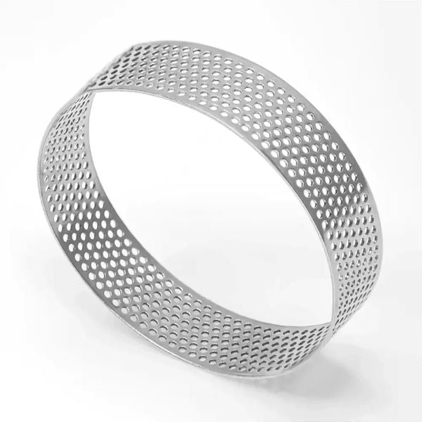 This image features a stainless steel perforated tart ring. The ring has a round shape with a diameter of 8 cm and a height of 2 cm. It is constructed from stainless steel and features numerous small holes evenly distributed throughout its surface, allowing for even cooking and airflow. The ring is set against a plain light background, highlighting its shiny metallic finish.