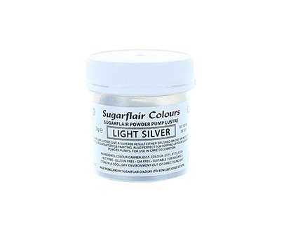 The image shows a small jar of Sugarflair Colors edible glitter dust powder. The jar is labeled &quot;Light Silver&quot; and contains 25 grams of the product. The container is primarily white with a clear lid, and the label includes details about the product type and usage instructions.