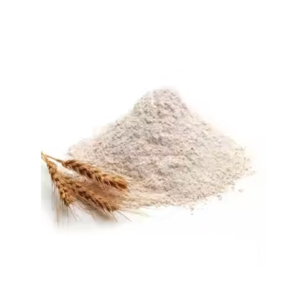 A pile of flour is displayed alongside a few stalks of wheat. The flour is light-colored and finely textured, creating a slight mound. The wheat stalks, which are golden and have a natural organic appearance, are positioned to the left of the flour. The background is plain, focusing on the flour and wheat.