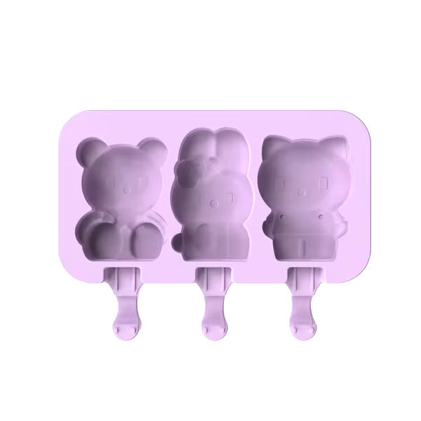 A purple silicone mould for making teddy bear-shaped popsicles, featuring three cavities. The mould includes three distinct figures: a teddy bear on the left, a character with a bow in the middle, and a bear-like figure on the right, each designed to hold a stick for easy handling.