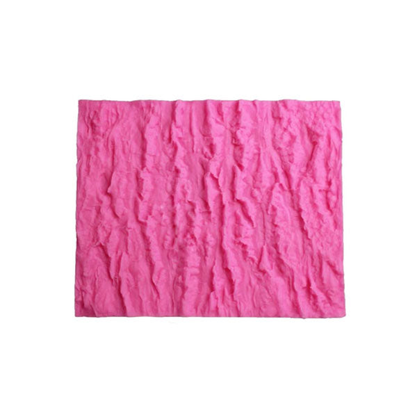 A pink silicone mat featuring a textured surface that resembles tree bark. The mat is rectangular and showcases deep grooves and ridges, mimicking the natural pattern of bark. This product is intended for making fondant impressions, suitable for cake decorating and similar applications.
