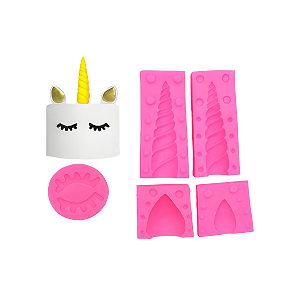 The image features a set of silicone molds designed for creating unicorn-themed decorations. It includes a smiling unicorn head with a golden horn and closed eyes, surrounded by several pink silicone molds. The molds consist of two vertical unicorn horn molds, a round mold with eye shapes, and two additional molds in different designs, possibly for creating unicorn features or accessories. The overall color scheme is vibrant, with white, pink, and golden elements.