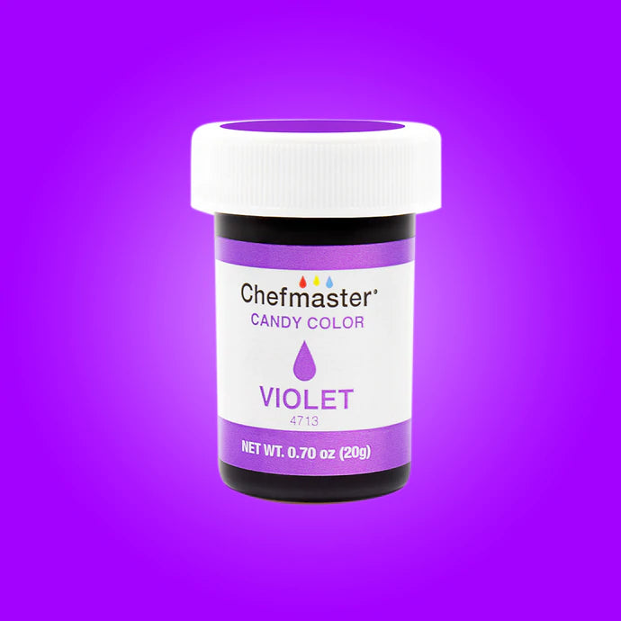 The image features a jar of Chefmaster Candy Color in violet. The jar is cylindrical with a white lid and a black base. The label on the jar includes the brand name &quot;Chefmaster,&quot; the product name &quot;Candy Color,&quot; and the color &quot;VIOLET.&quot; It also has a weight indication of 0.70 oz (20 g) and the product code &quot;4713.&quot; The background is a solid violet color, enhancing the theme of the product.