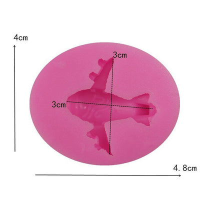 An oval-shaped silicone mold in bright pink, featuring an airplane design in the center. The mold measures approximately 4.8 cm in width and 4 cm in height. The airplane shape is marked with measurement lines indicating it is 3 cm wide and 3 cm tall. The mold is designed for making airplane-shaped items, suitable for baking or crafting.