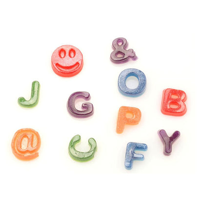 Colorful candy shaped like letters and symbols, including a happy face, ampersand, and @ symbol, scattered playfully on a white background.