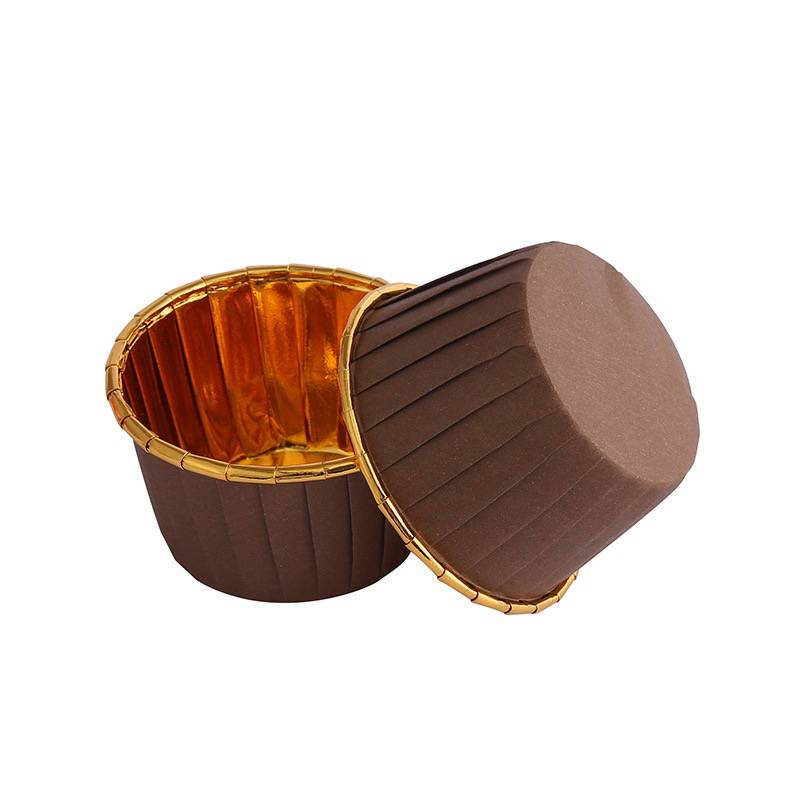 Image description: Two aluminium foil ramekins are displayed, one upright and the other tilted on its side. The ramekins have a shiny gold interior and a brown, textured exterior. The brown exterior features vertical ridges. The image showcases the design and material of the baking cups, indicating they are suitable for baking and serving.