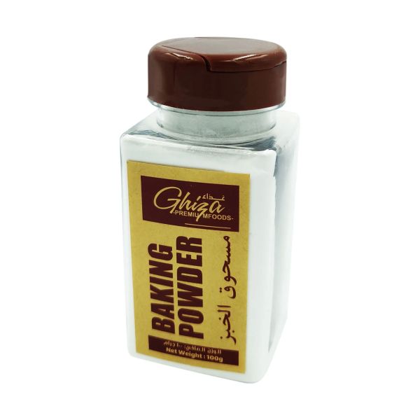 A clear glass container of baking powder with a brown lid. The label on the front features the brand name &quot;Ghiza&quot; in a stylized font, along with the words &quot;BAKING POWDER&quot; prominently displayed. The label also includes Arabic text and indicates a net weight of 100 grams. The overall design is simple and clean, with a white and brown color scheme.