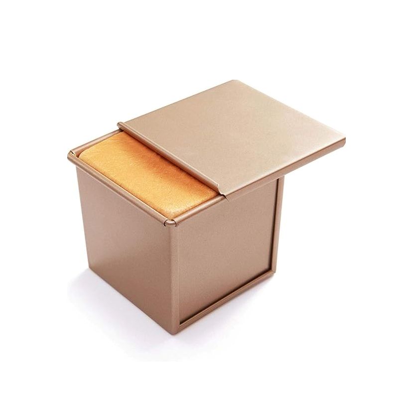 Beige Bread mold with the lid open and bread inside on a white background