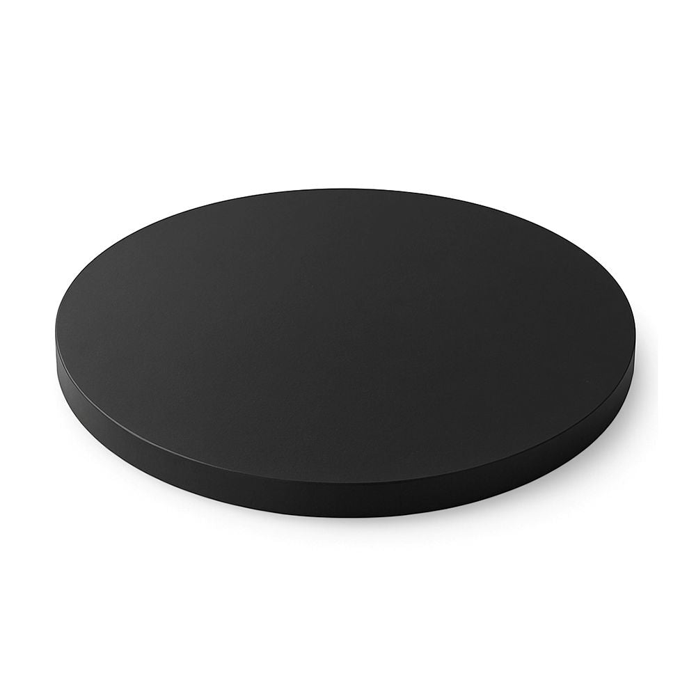 A black circular table top placed on a white surface, highlighting a minimalist aesthetic.