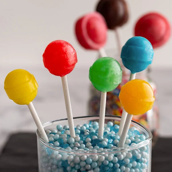 Colorful lollipops in a glass container with blue and white beads.