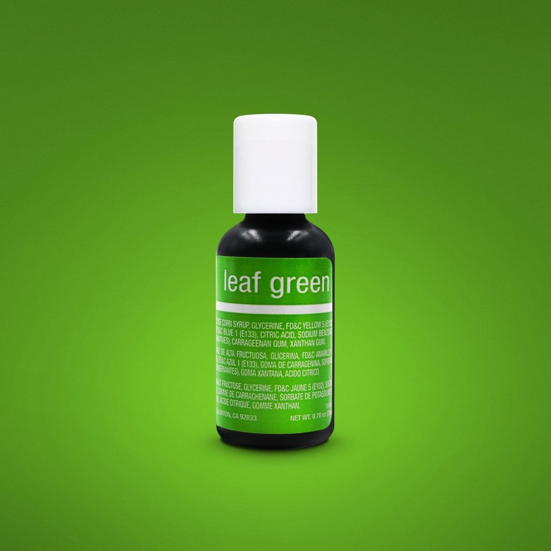 Image of a bottle of Chefmaster Liqua-Gel Color in "Leaf Green." The bottle is black with a white cap and features a bright green label displaying the product name, "leaf green," and ingredient information. The background is a solid green color, enhancing the visibility of the product. The bottle contains 0.7 oz (20 ml) of the coloring.