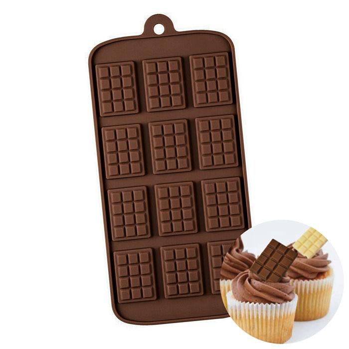 A chocolate bar mini silicone mould, featuring a design with twelve rectangular sections that resemble chocolate squares. The mould is made of dark silicone and has a hanging loop for easy storage. An inset image shows a cupcake topped with chocolate frosting and a small chocolate piece being placed on top.